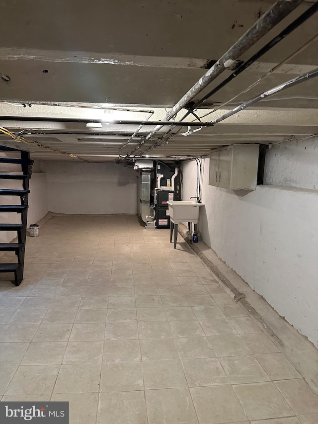 basement with sink and light tile patterned floors