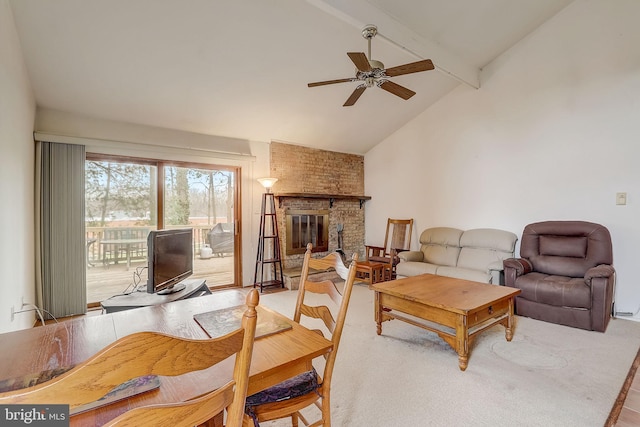 living room featuring lofted ceiling with beams, ceiling fan, and a brick fireplace