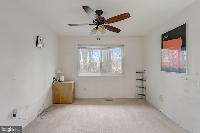 carpeted spare room featuring ceiling fan