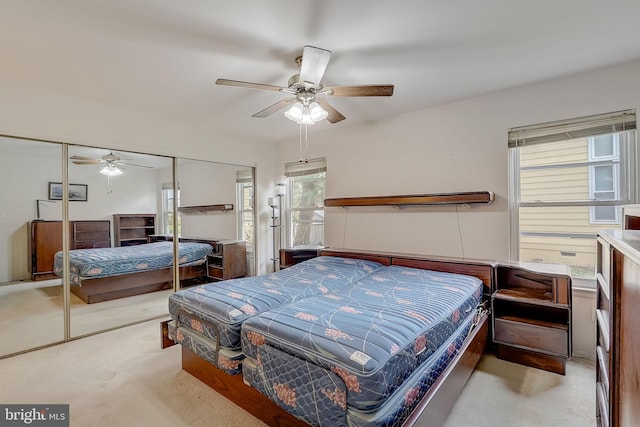 carpeted bedroom featuring ceiling fan and a closet