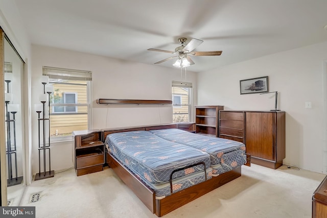 bedroom featuring ceiling fan, light carpet, and a closet