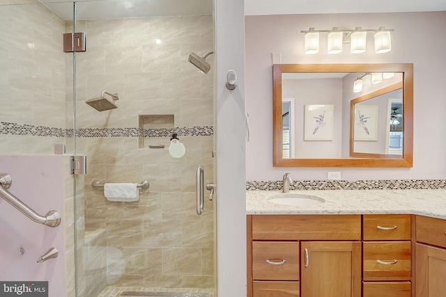 bathroom featuring decorative backsplash, an enclosed shower, and vanity