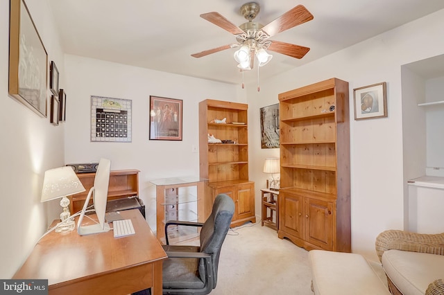 carpeted home office featuring ceiling fan