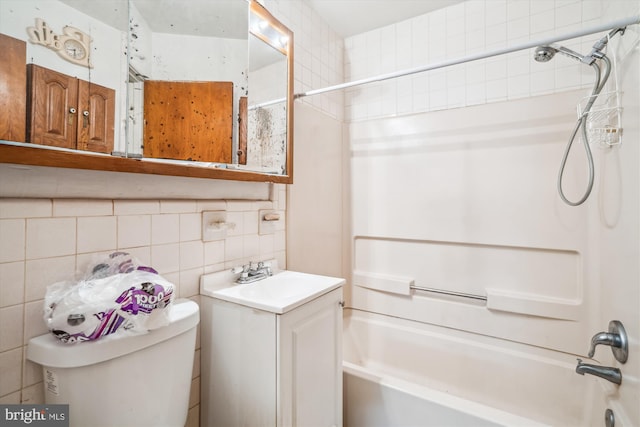 full bathroom featuring bathing tub / shower combination, tile walls, backsplash, vanity, and toilet