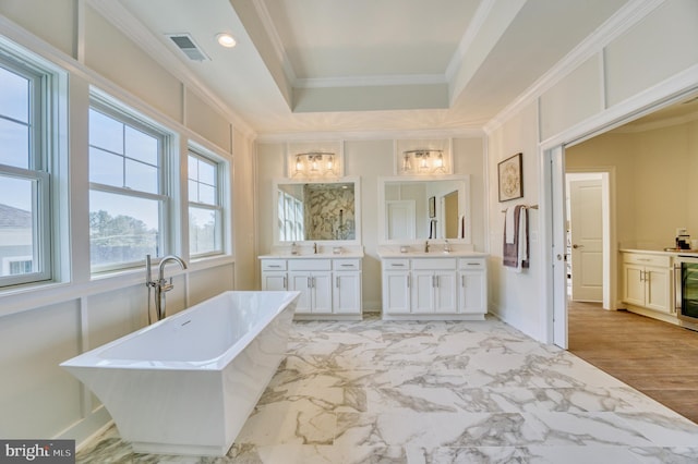 bathroom with a tub to relax in, crown molding, and vanity