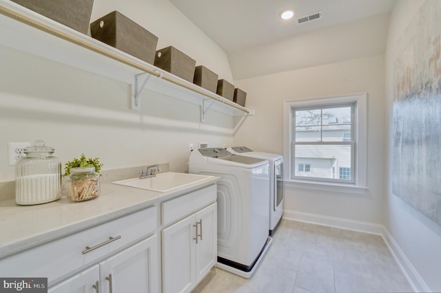 laundry area featuring separate washer and dryer, cabinets, sink, and light tile patterned floors