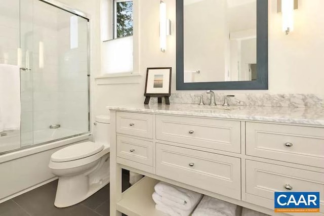 full bathroom with vanity, toilet, and bath / shower combo with glass door