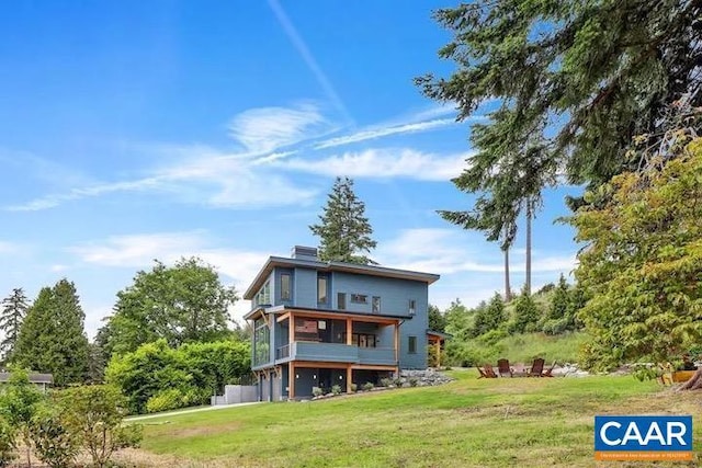 back of property featuring a sunroom and a lawn