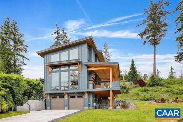 rear view of property featuring a lawn and a garage