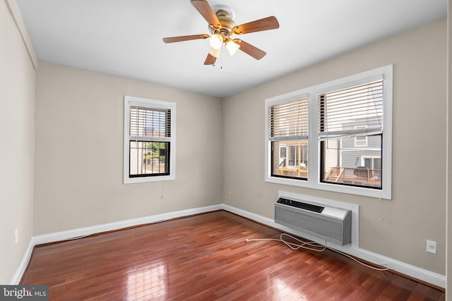 spare room featuring a wall mounted AC, ceiling fan, and hardwood / wood-style floors