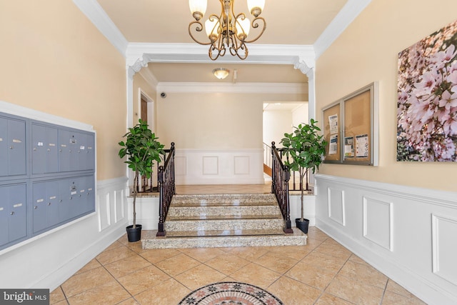 staircase featuring tile patterned floors, mail boxes, an inviting chandelier, and ornamental molding