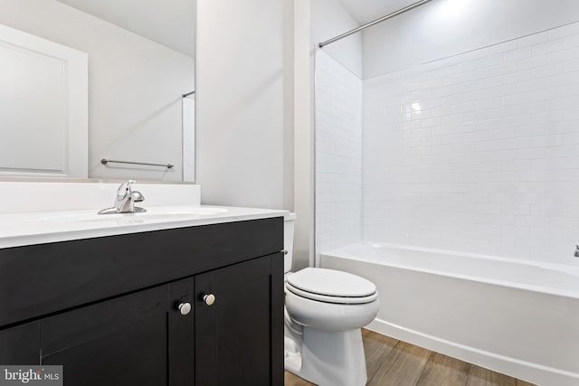 full bathroom with toilet, bathing tub / shower combination, hardwood / wood-style floors, and vanity