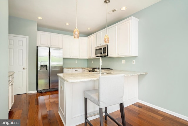 kitchen with pendant lighting, white cabinetry, kitchen peninsula, and appliances with stainless steel finishes