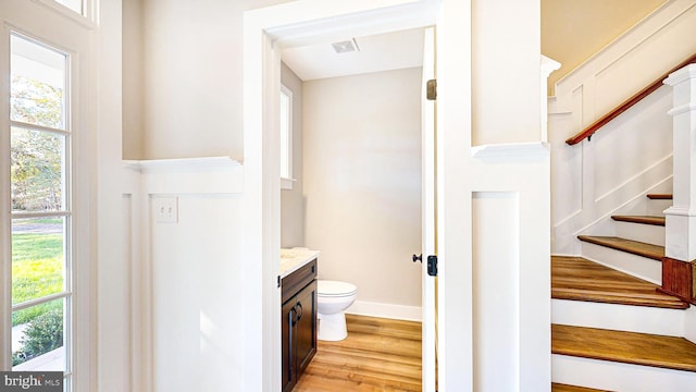 bathroom with baseboards, visible vents, toilet, wood finished floors, and vanity