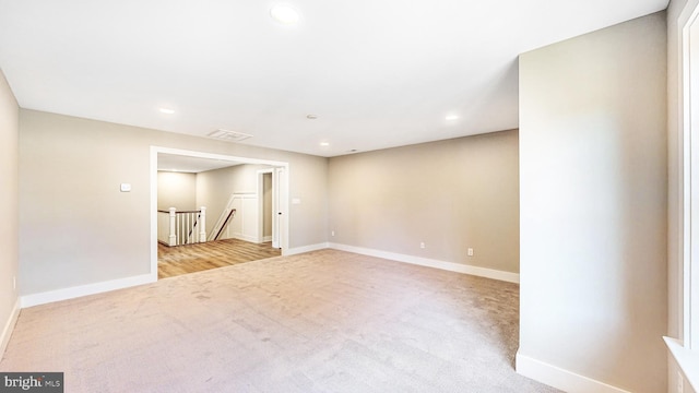 spare room featuring recessed lighting, light carpet, visible vents, and baseboards