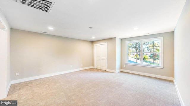 empty room featuring light carpet, baseboards, visible vents, and recessed lighting