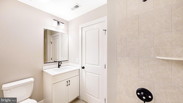 bathroom featuring toilet, vanity, and visible vents