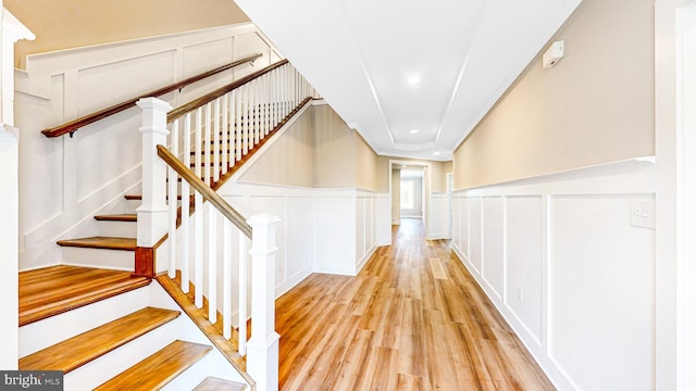 corridor with a decorative wall and light wood-style flooring