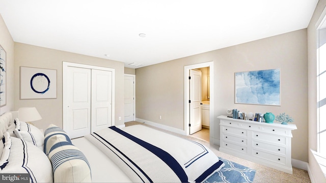 bedroom with light carpet, a closet, connected bathroom, and baseboards