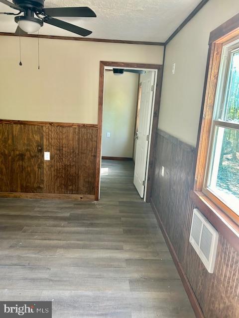 spare room featuring wood-type flooring, a textured ceiling, and ceiling fan