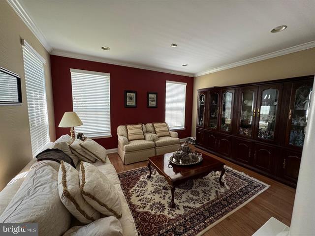 living room with hardwood / wood-style flooring and crown molding