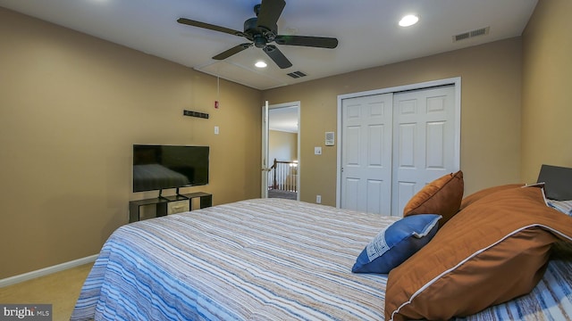 bedroom with ceiling fan, a closet, and light carpet