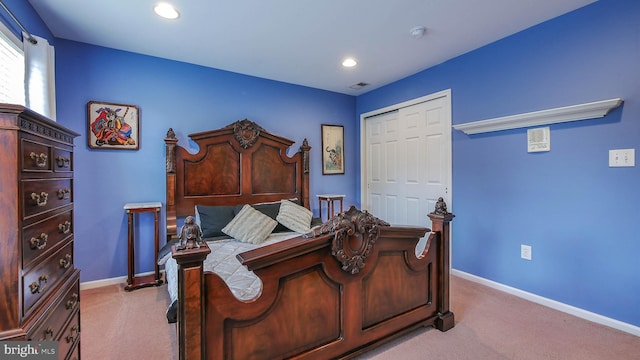 bedroom with light carpet and a closet