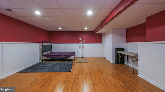 interior space with hardwood / wood-style flooring and a drop ceiling