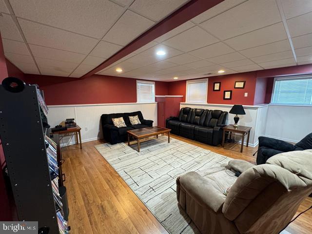 living room featuring a drop ceiling and light hardwood / wood-style flooring