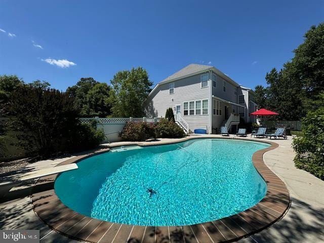 view of pool with a diving board and a patio