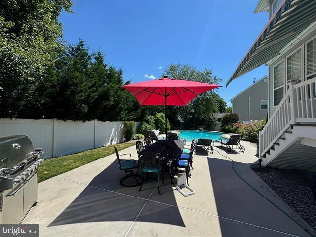 view of patio / terrace featuring a fenced in pool and grilling area