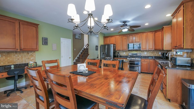 dining space featuring sink, light tile patterned floors, and ceiling fan with notable chandelier