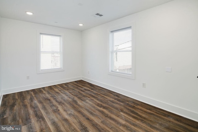 unfurnished room with dark wood-type flooring and plenty of natural light