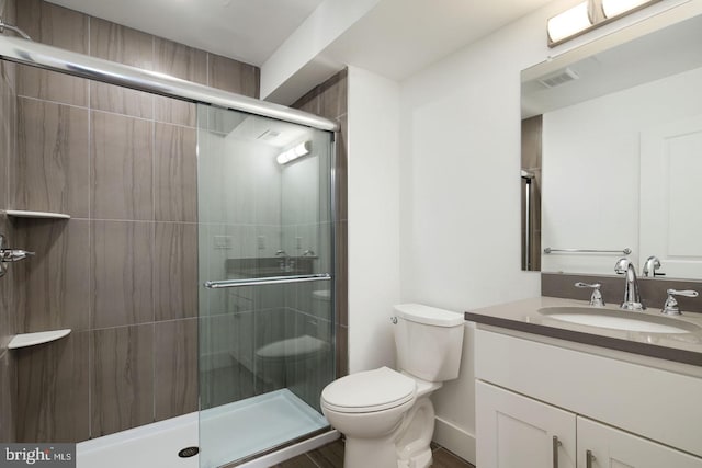 bathroom with vanity, toilet, and an enclosed shower