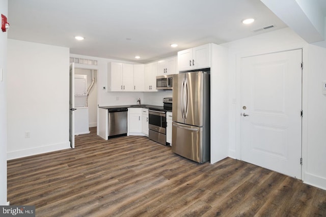 kitchen with sink, stainless steel appliances, white cabinetry, and dark hardwood / wood-style floors