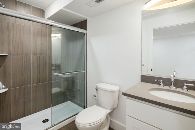 bathroom with a shower with shower door, toilet, and vanity