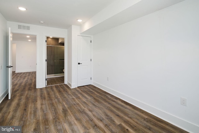 unfurnished bedroom featuring dark hardwood / wood-style floors and ensuite bath