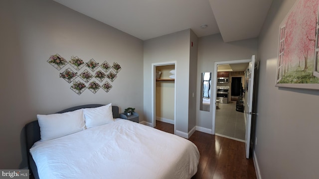 bedroom featuring dark hardwood / wood-style floors, a walk in closet, and a closet