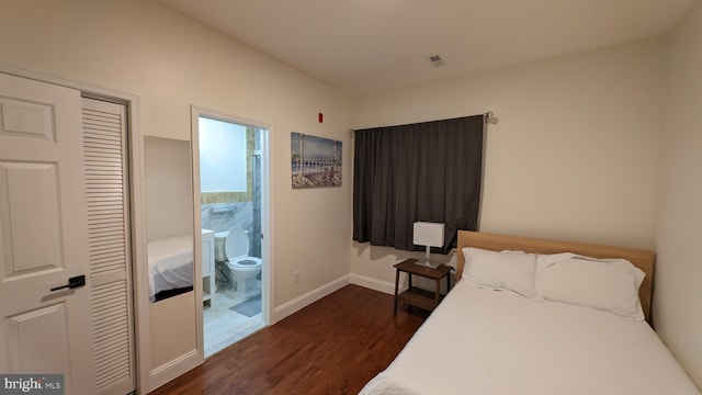 bedroom with dark hardwood / wood-style flooring, connected bathroom, and a closet