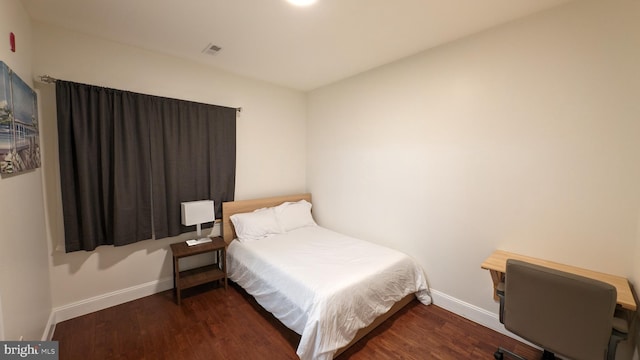 bedroom with dark hardwood / wood-style flooring