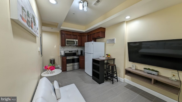 kitchen featuring appliances with stainless steel finishes, tasteful backsplash, and light tile patterned floors