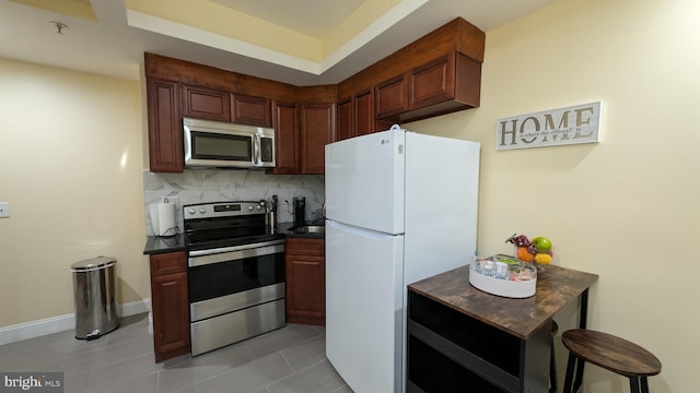 kitchen with backsplash, a breakfast bar, light tile patterned floors, and appliances with stainless steel finishes