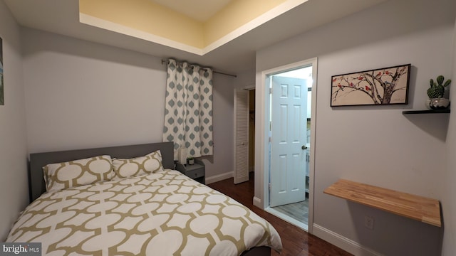 bedroom featuring dark hardwood / wood-style floors and a raised ceiling