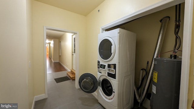 washroom featuring stacked washer / drying machine and water heater