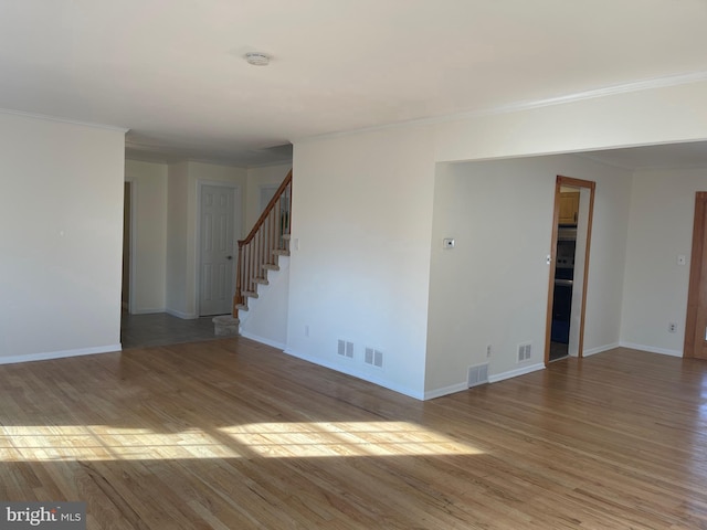 spare room featuring hardwood / wood-style flooring and ornamental molding