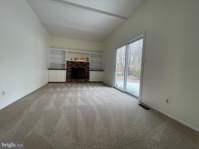 unfurnished living room featuring light carpet, lofted ceiling with beams, and a fireplace