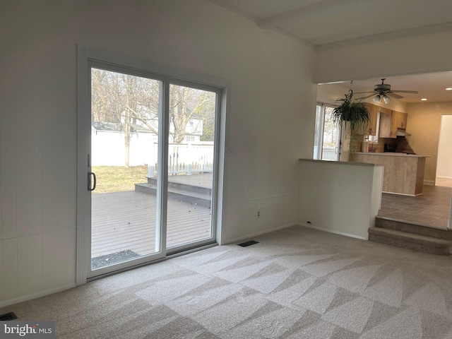 unfurnished living room featuring light colored carpet and ceiling fan