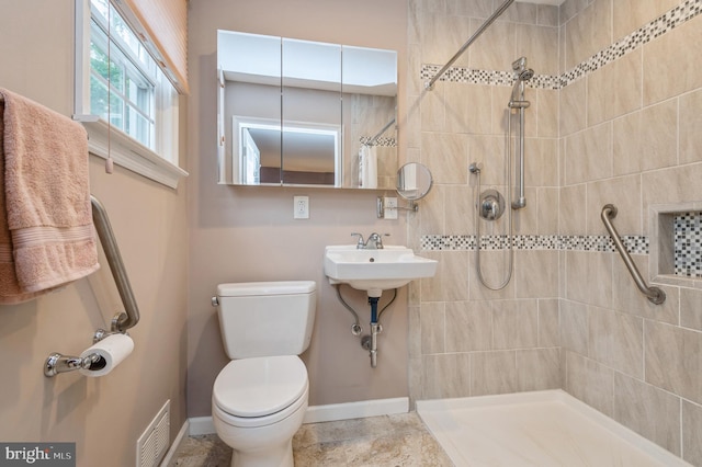 bathroom featuring walk in shower, sink, and toilet