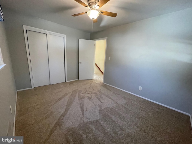 unfurnished bedroom featuring ceiling fan, a closet, and light carpet