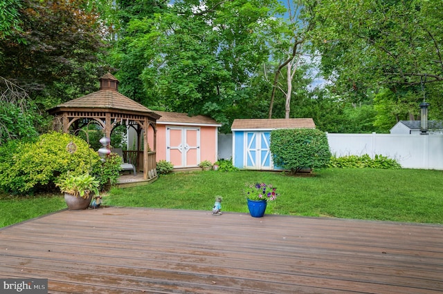 wooden deck featuring a gazebo, a yard, and a shed